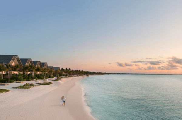 couple walks on beach at mayakoba